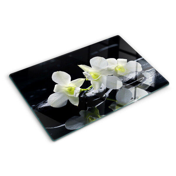 Glas-Schneidebrett mit Orchideenmotiv auf schwarzem Hintergrund