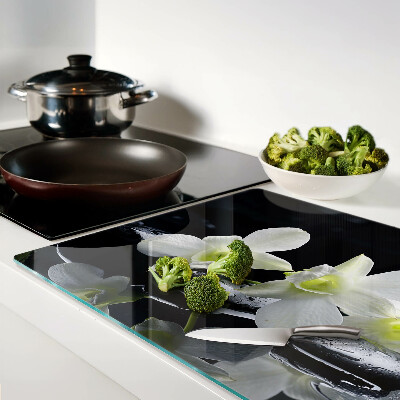 Glas-Schneidebrett mit Orchideenmotiv auf schwarzem Hintergrund