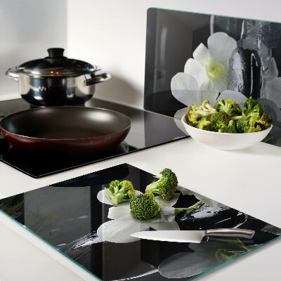 Glas-Schneidebrett mit Orchideenmotiv auf schwarzem Hintergrund