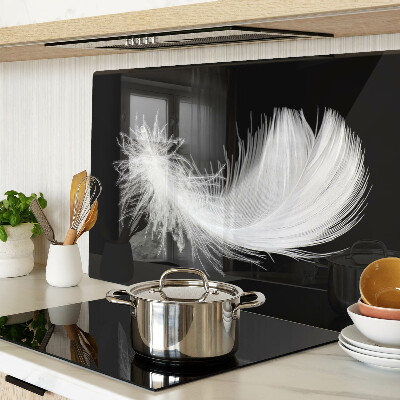 Schneidebrett glas Feder auf schwarzem Hintergrund