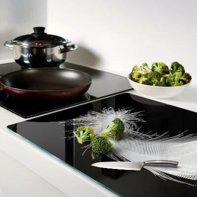 Schneidebrett glas Feder auf schwarzem Hintergrund