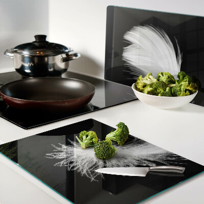 Schneidebrett glas Feder auf schwarzem Hintergrund