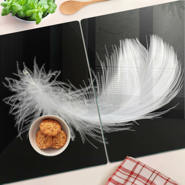 Schneidebrett Glas mit Motiv einer Feder auf schwarzem Hintergrund