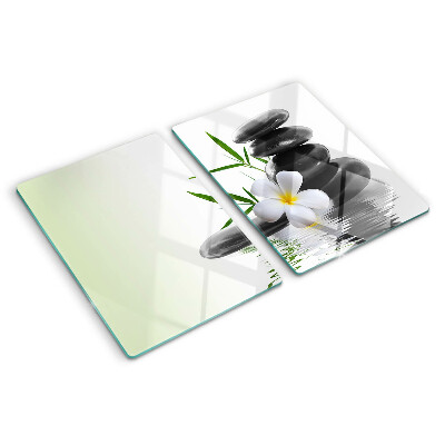 Schneidebrett mit Motiv aus Blumen und Kieselsteinen auf Wasser