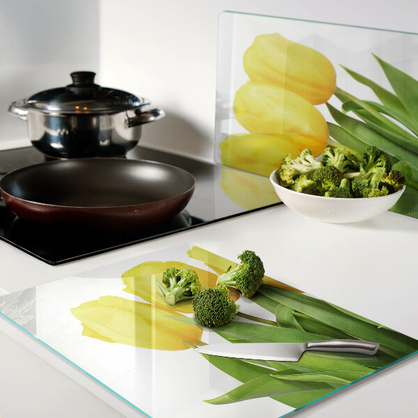 Schneidebrett mit gelben Tulpen vor grünem Hintergrund