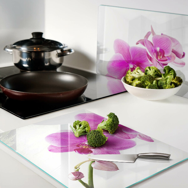 Glas-Schneidebrett mit Orchideen in Rosatönen