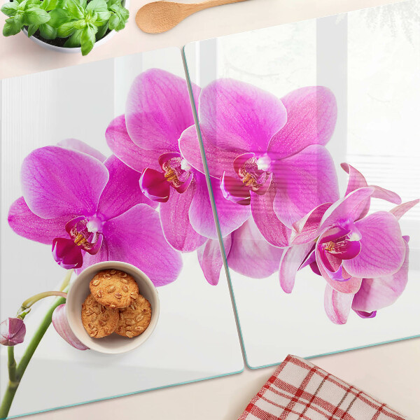 Glas-Schneidebrett mit Orchideen in Rosatönen