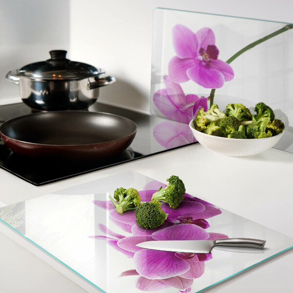 Schneidebrett mit Orchideenblüten in Rosatönen