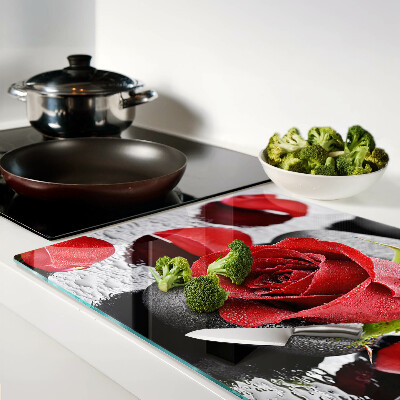 Glas schneidebrett Rose auf Steinen mit Wassertropfen