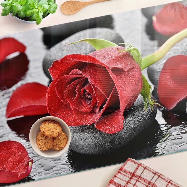 Glas schneidebrett Rose auf Steinen mit Wassertropfen