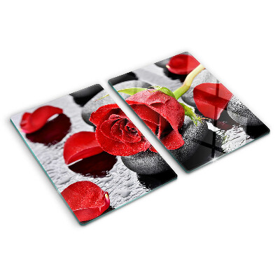 Glas schneidebrett Rose auf Steinen mit Wassertropfen