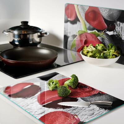 Glas-Schneidebrett mit Motiv einer Rose auf Steinen und Wassertropfen