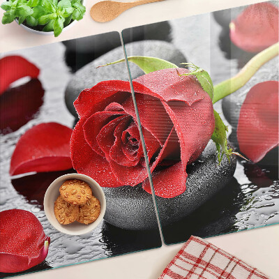 Glas schneidebrett Rose auf Steinen mit Wassertropfen
