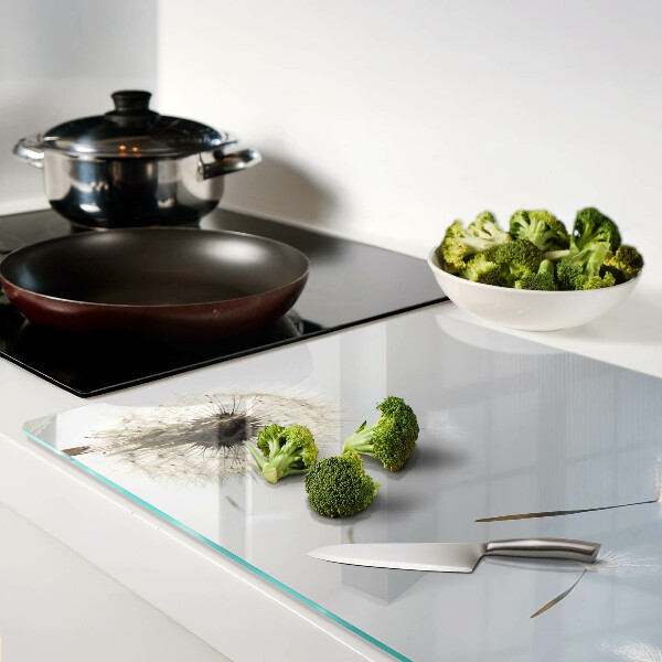 Schneidebrett mit Motiv eines Löwenzahns vor einem Fenster