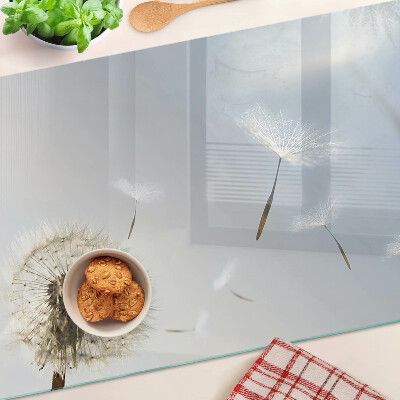 Schneidebrett mit Motiv eines Löwenzahns vor einem Fenster