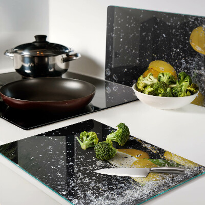 Glas schneidebrett Zitronen in Wasser