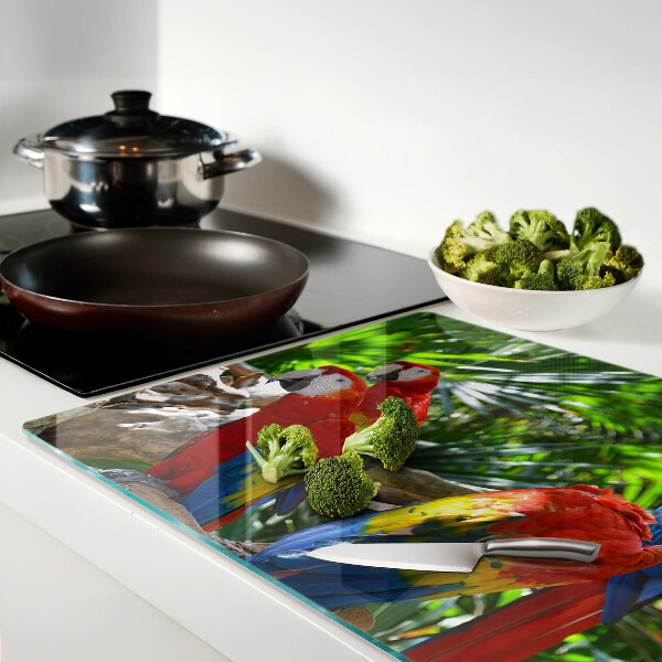 Glas-Schneidebrett mit Papageienmotiv in einer tropischen Umgebung