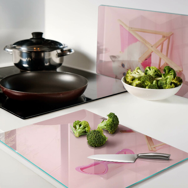 Schneidebrett Ein Kätzchen auf einem Liegestuhl vor rosa Hintergrund