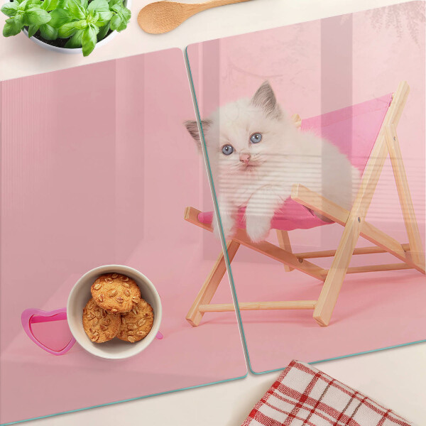 Schneidebrett mit Motiv eines Kätzchens auf einem Liegestuhl vor rosa Hintergrund