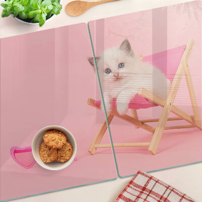 Schneidebrett mit Motiv eines Kätzchens auf einem Liegestuhl vor rosa Hintergrund