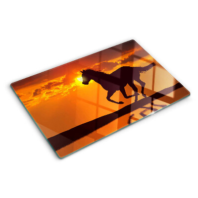 Schneidebrett Ein Pferd vor dem Hintergrund der untergehenden Sonne