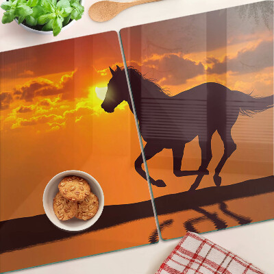 Schneidebrett mit Pferdemotiv vor untergehender Sonne