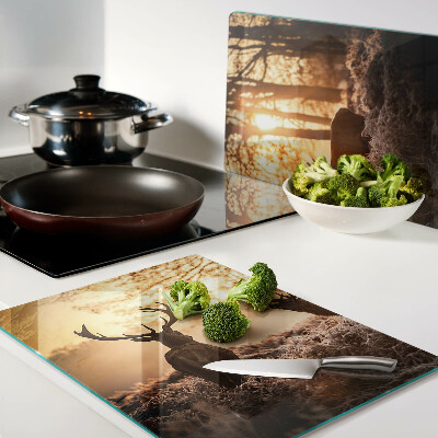 Schneidebrett Hirsche im Wald bei Sonnenuntergang