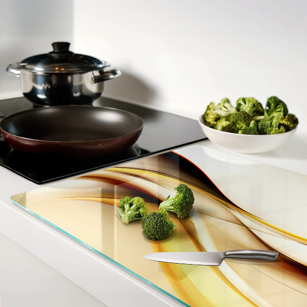 Schneidebrett Glas mit abstraktem Wellenmotiv in Goldtönen