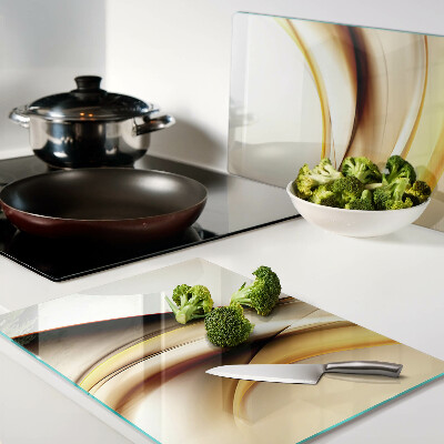Schneidebrett Glas mit abstraktem Wellenmotiv in Goldtönen