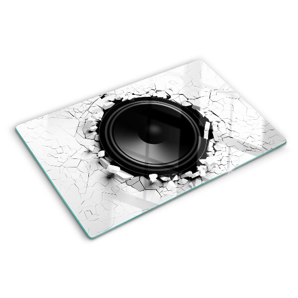 Schneidebrett mit Lautsprecher-Motiv vor einer zerbrochenen Wand