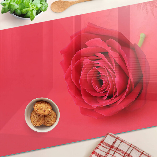 Schneidebrett mit Motiv einer roten Rose im Hintergrund