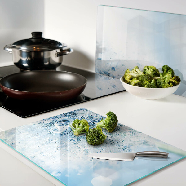 Glas-Schneidebrett mit einem Motiv aus Löwenzahnblüten und Wassertropfen