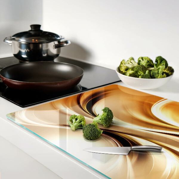 Glas-Schneidebrett mit abstraktem Wellenmotiv in Goldtönen