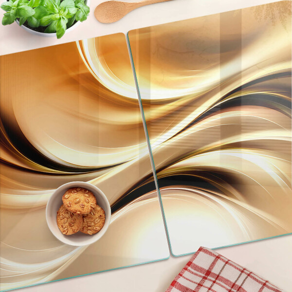 Glas-Schneidebrett mit abstraktem Wellenmotiv in Goldtönen