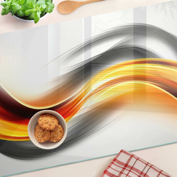 Glas-Schneidebrett mit Wellenmotiv in Orange und Schwarz