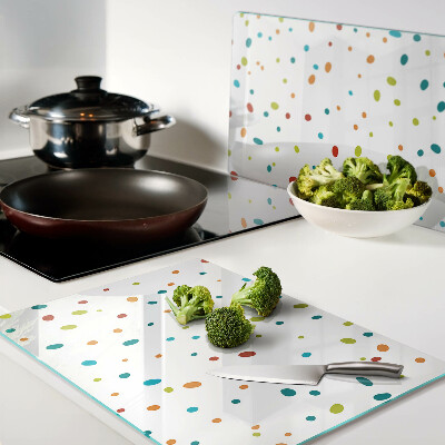 Glas-Schneidebrett mit bunten Punkten auf weißem Hintergrund