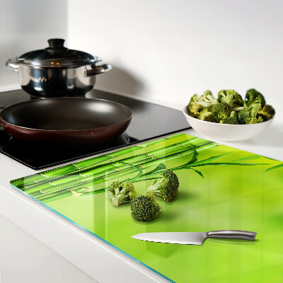 Schneidebrett glas Bambus auf grünem Hintergrund