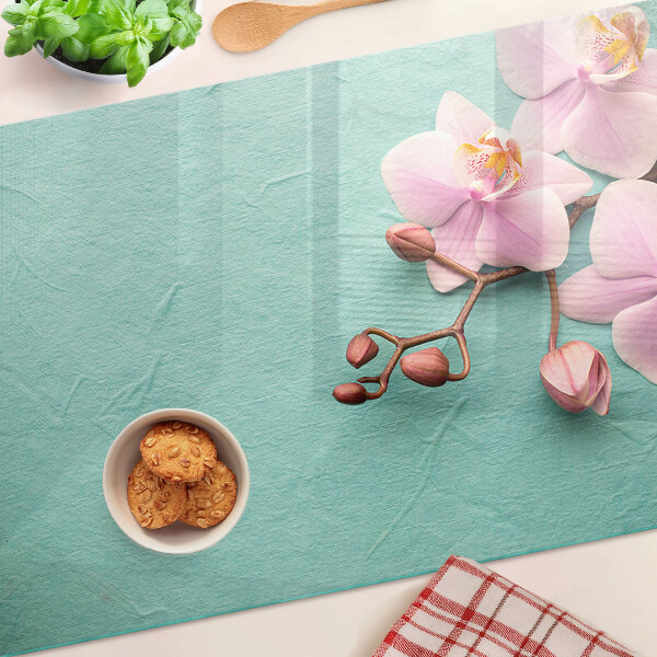 Glas schneidebrett Orchideen auf blauem Hintergrund