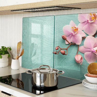 Glas Schneidebrett mit Orchideenmotiv auf blauem Hintergrund