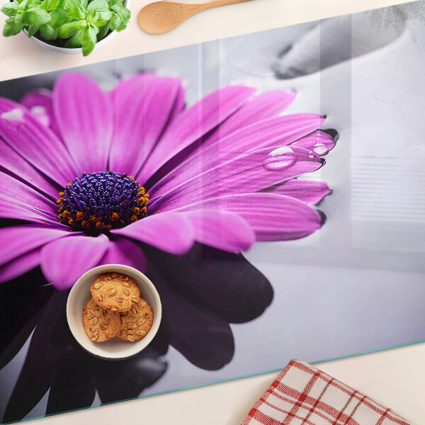 Glas-Schneidebrett mit lila Blumenmotiv und Wassertropfen