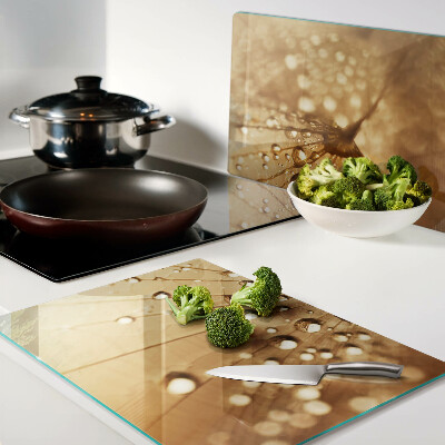 Glas schneidebrett mit Motiv von Wassertropfen auf einem Löwenzahn