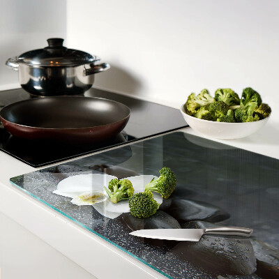 Schneidebrett mit Motiv einer Orchideenblüte auf Steinen