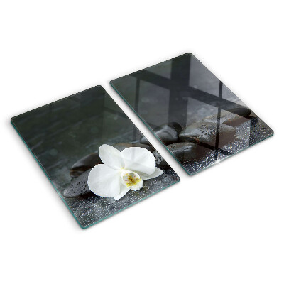 Schneidebrett mit Motiv einer Orchideenblüte auf Steinen
