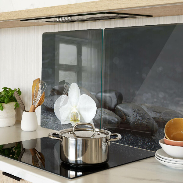 Schneidebrett mit Motiv einer Orchideenblüte auf Steinen