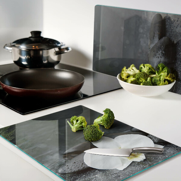 Schneidebrett mit Motiv einer Orchideenblüte auf Steinen