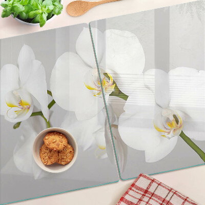 Schneidebrett mit Orchideen vor spiegelndem Hintergrund