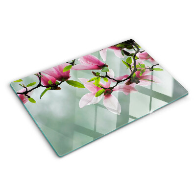 Schneidebrett Magnolienblüten vor grünem Hintergrund