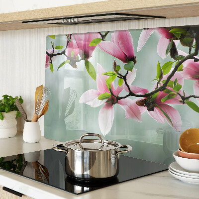 Schneidebrett mit Motiv aus Magnolienblüten vor grünem Hintergrund