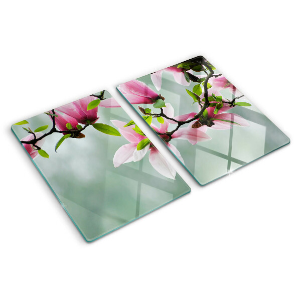 Schneidebrett mit Motiv aus Magnolienblüten vor grünem Hintergrund