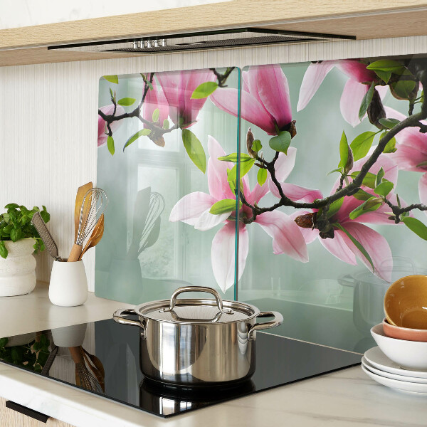 Schneidebrett mit Motiv aus Magnolienblüten vor grünem Hintergrund